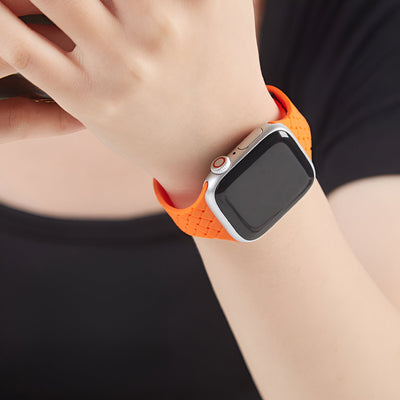 Bracelet Apple Watch en silicone orange perforé, style sportif, ajusté au poignet.