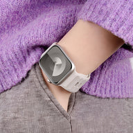 Bracelet Apple Watch en silicone beige clair porté avec un pull violet en laine côtelée.