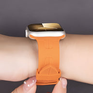 Bracelet Apple Watch en silicone orange modèle Luxa, ajusté sur poignet, boucle classique.
