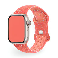 Bracelet Apple Watch silicone rose à motifs multicolores perforé style sport.