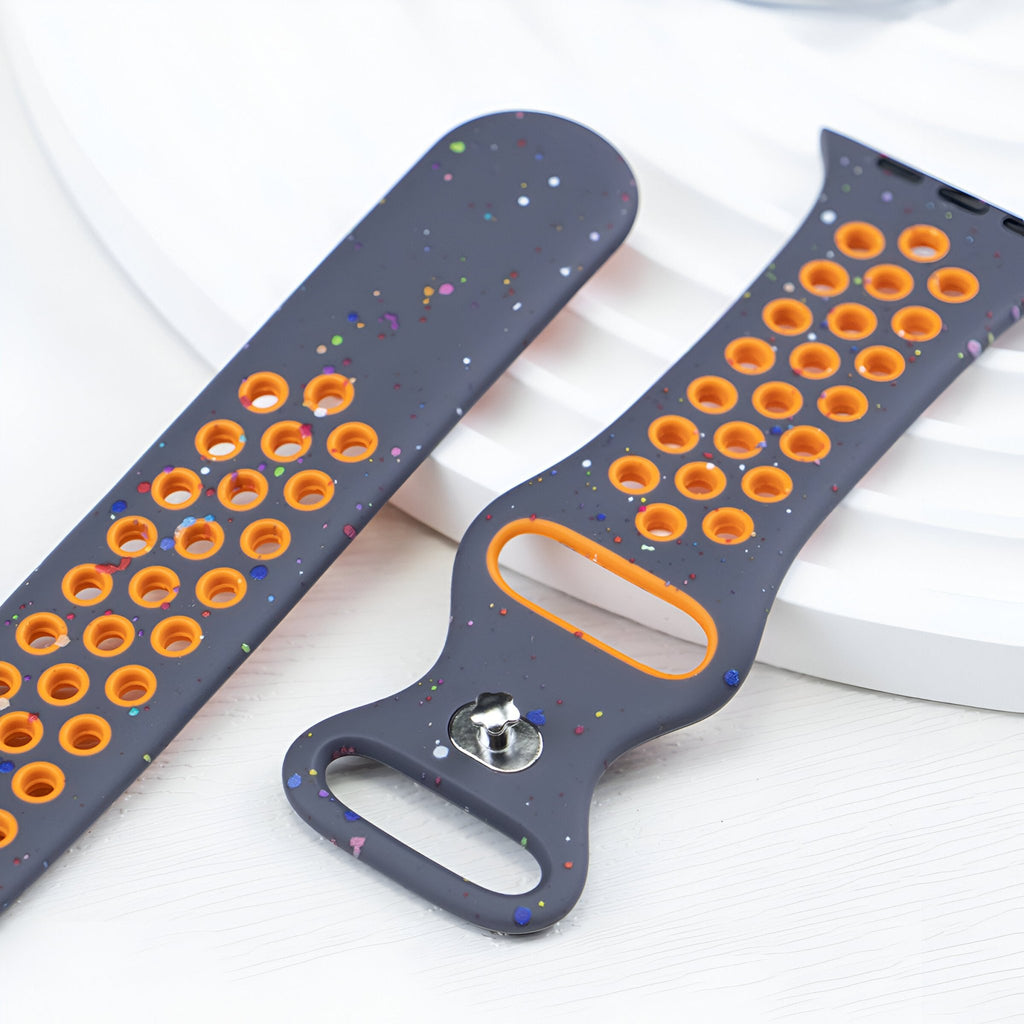 Bracelet Apple Watch silicone gris foncé perforé avec détails orange et motifs multicolores petites taches.