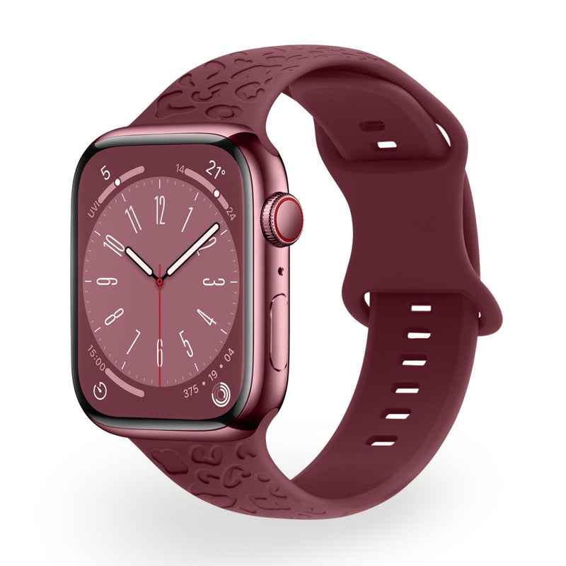 Bracelet en silicone bordeaux pour Apple Watch avec motifs gravés, finition lisse et boucle ajustable.