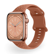 Bracelet Apple Watch en silicone marron avec motif texturé et boucle classique.