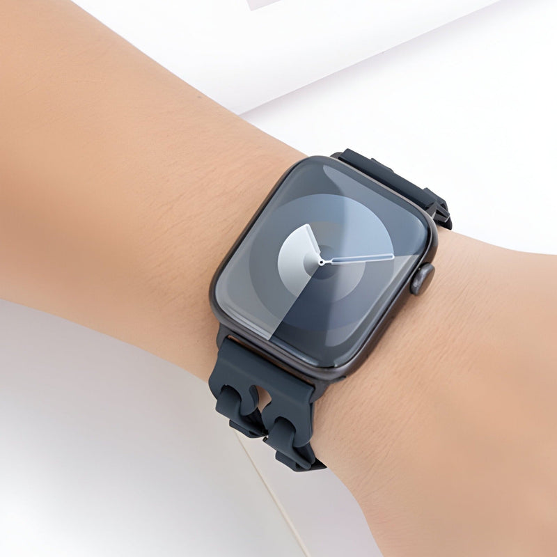 Bracelet Apple Watch silicone noir avec design texturé et boucle ajustable sur poignet clair.
