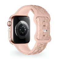 Bracelet Apple Watch en silicone rose clair avec motif floral en relief, modèle Nexus.