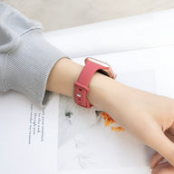 Bracelet Apple Watch silicone rose pour femme porté au poignet, style épuré et ajustable.