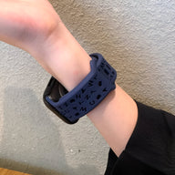 Bracelet Apple Watch silicone bleu foncé avec motifs géométriques, taille 38-42 mm, porté au poignet féminin.
