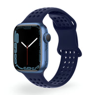 Bracelet Apple Watch silicone bleu marine perforé, design sport pour femme, fermeture ajustable.
