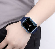 Bracelet Apple Watch en silicone bleu marine, ajustable, porté au poignet féminin.