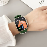 Bracelet Apple Watch en silicone vert style brique, porté sur un poignet féminin.