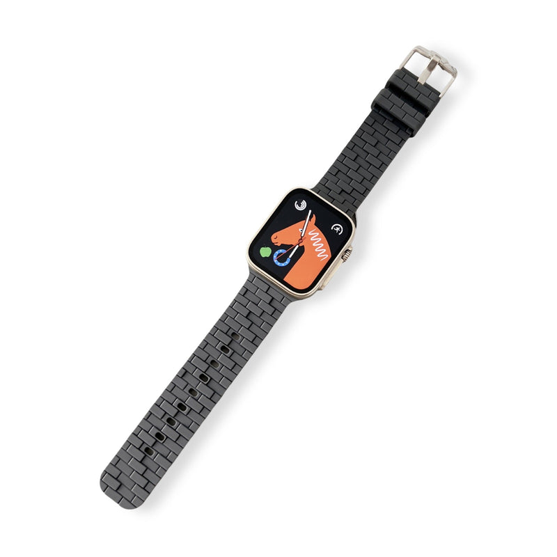 Bracelet Apple Watch en silicone noir style brique avec boucle argentée pour femme.