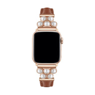 Bracelet Apple Watch en simili cuir taupe avec perles blanches sur un boîtier doré rose.
