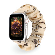 Bracelet Apple Watch en tissu élastique beige à motif floral noir et marron, style scrunchie.