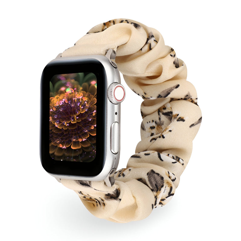 Bracelet Apple Watch en tissu élastique beige à motif floral noir et marron, style scrunchie.