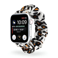 Bracelet Apple Watch en tissu élastique blanc à motif léopard noir et marron, style scrunchie.