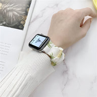 Bracelet élastique Apple Watch blanc à motif floral vert et jaune, style féminin élégant.