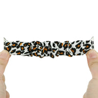 Bracelet Apple Watch en tissu élastique blanc avec motif léopard noir et marron, style scrunchie, pour femme.