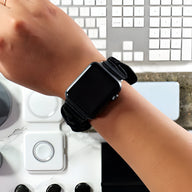 Bracelet Apple Watch Nyssara en tissu élastique noir porté au poignet féminin, design sport et élégant.