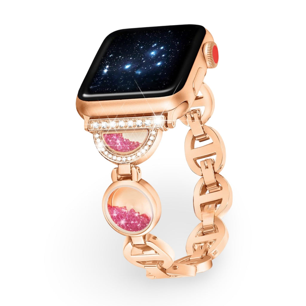 Bracelet Apple Watch or rosé avec incrustation de sable rose et détails en pierres blanches.