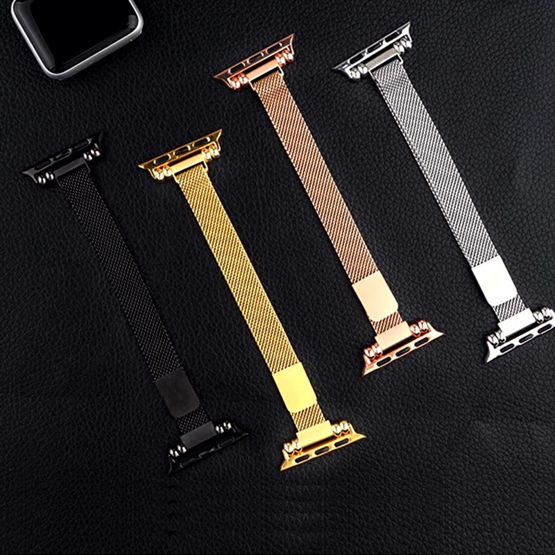 Quatre bracelets Apple Watch maille milanaise, couleurs noir, or, or rosé et argent, fermoirs assortis.