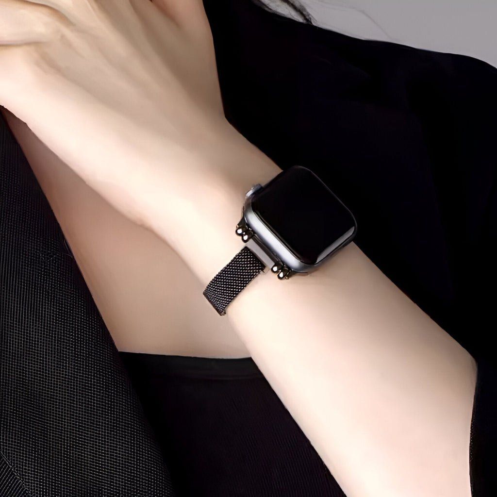 Bracelet Apple Watch maille milanaise noir ajusté poignet femme, style élégant et moderne.