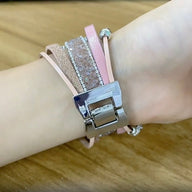 Bracelet Apple Watch multi-rangs rose et paillettes, charm cœur argenté, fermoir métallique acier inoxydable.