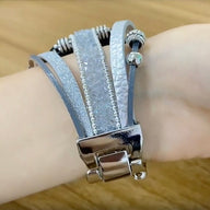 Bracelet Apple Watch multi-rangs argent avec charm cœur et détail paillettes sur poignet.