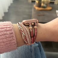 Bracelet Apple Watch multi-rangs rose avec motifs floraux et détails en métal doré.