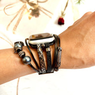 Bracelet multi-rangs noir avec plusieurs charms en métal et perles, pour Apple Watch, style bohème chic.