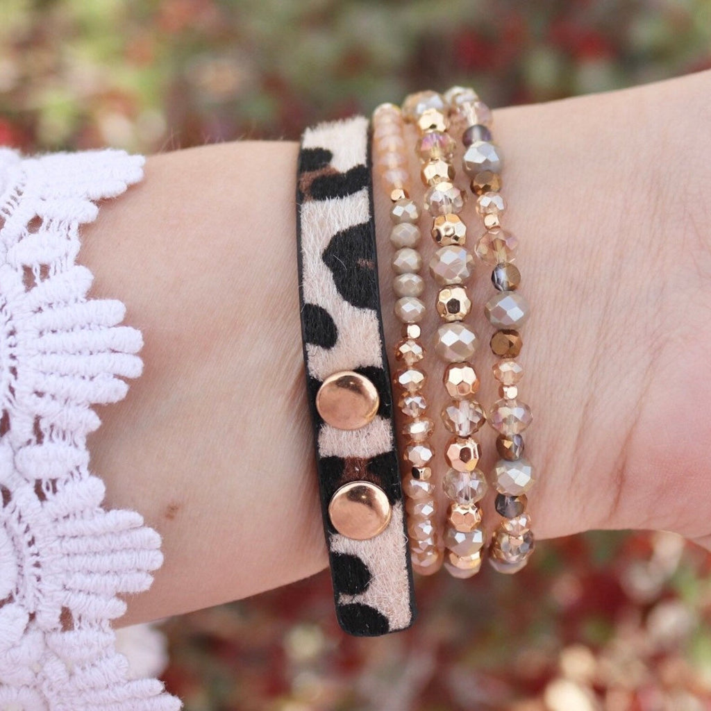 Bracelet Apple Watch multi-rangs Malia léopard avec perles et sequins dorés sur poignet féminin.