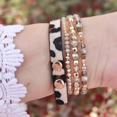 Bracelet Apple Watch multi-rangs Malia léopard avec perles et sequins dorés sur poignet féminin.