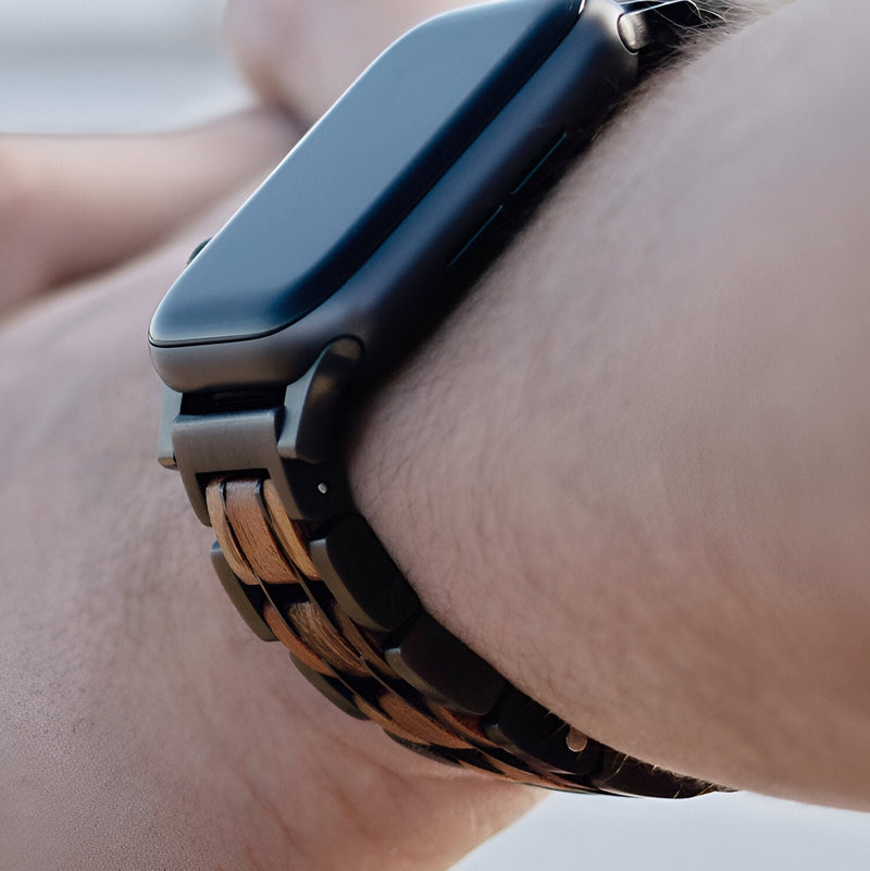 Bracelet en bois Guibourtia foncé avec maillons larges pour Apple Watch sur poignet masculin.