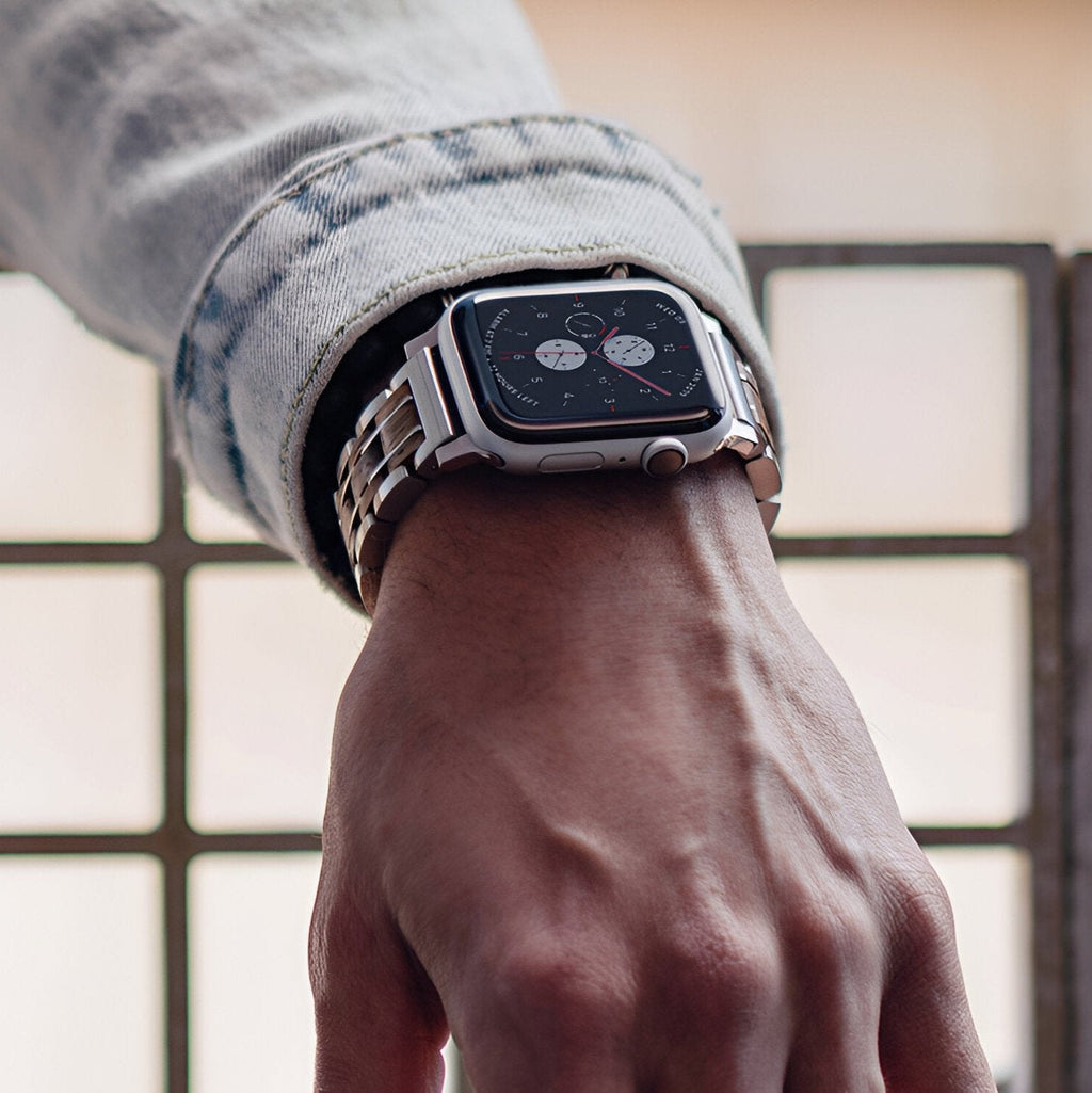 Bracelet pour Apple Watch en bois Zébrano avec maillons métalliques argentés sur poignet masculin.