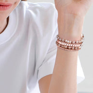 Bracelet de montre connectée rose en cristal scintillant avec chaînes fines et perles délicates.