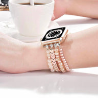 Bracelet de montre connectée rose en cristal scintillant orné de perles et maillons, style triple rangée.