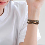 Bracelet de montre connectée marron en cristal scintillant porté au poignet, style multiple rangs élégants.