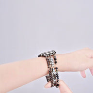 Bracelet rose en perles cristallines avec fermoir argenté pour Apple Watch sur poignet féminin.