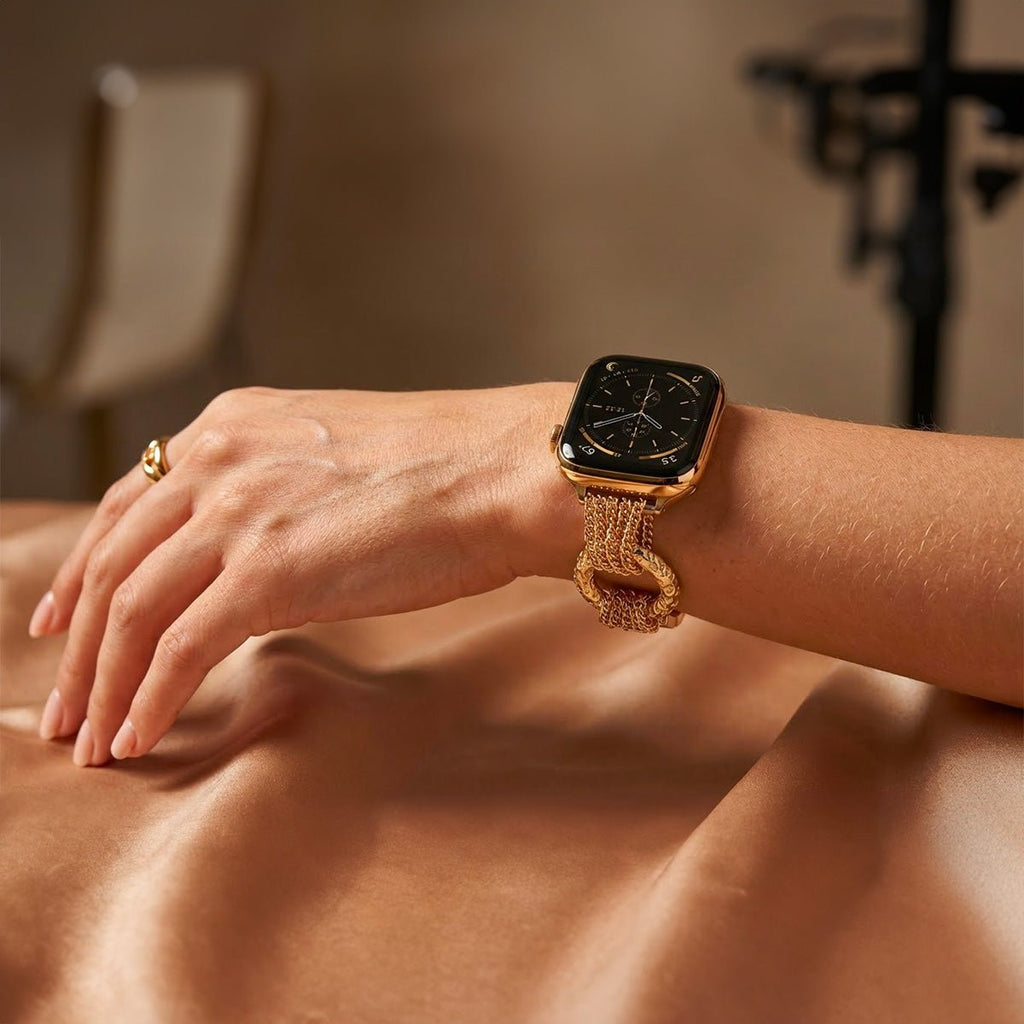 Bracelet pour Apple Watch en acier inoxydable doré, maille tressée multiple avec anneaux sculptés brillants, style luxe.