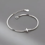Bracelet fin en argent sterling avec petite croix chrétienne centrale, chaîne délicate ajustable.