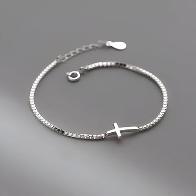 Bracelet fin en argent sterling avec petite croix chrétienne centrale, chaîne délicate ajustable.