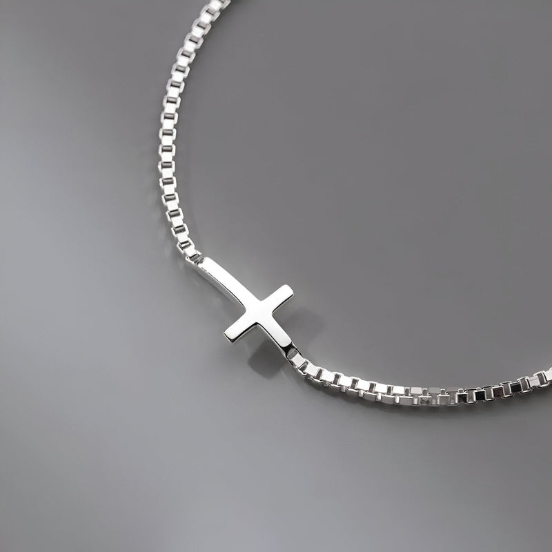 Bracelet fin en argent sterling avec pendentif croix chrétienne lisse et chaîne à maillons carrés.