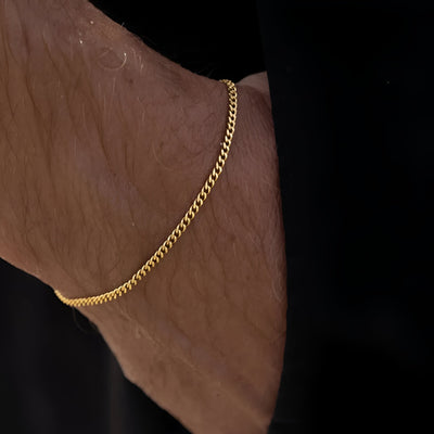 Bracelet fin chaîne en acier inoxydable doré, style discret pour homme, fermeture ajustable.
