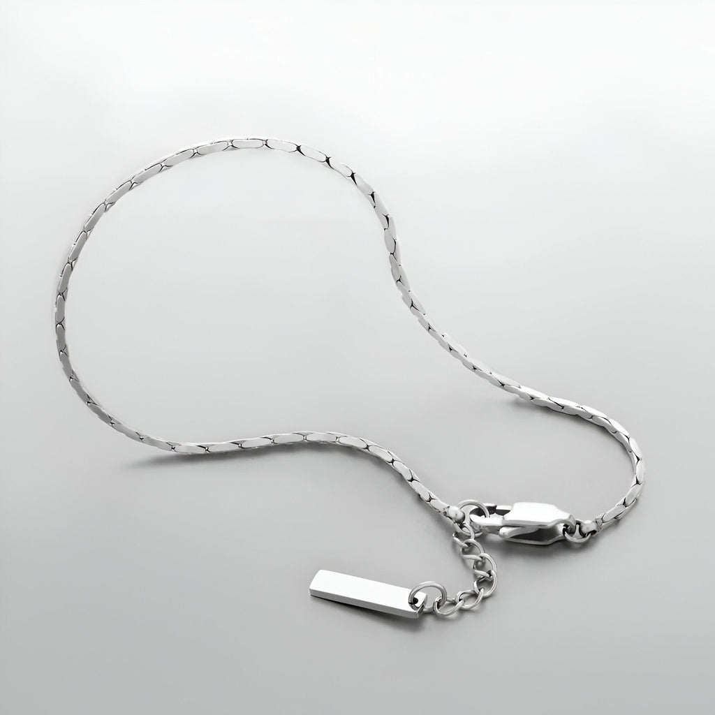 Bracelet homme en acier inoxydable argenté, chaîne fine avec petit pendentif rectangulaire lisse.