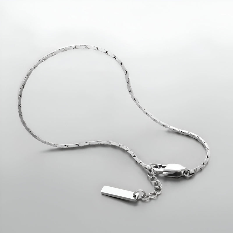 Bracelet homme en acier inoxydable argenté, chaîne fine avec petit pendentif rectangulaire lisse.