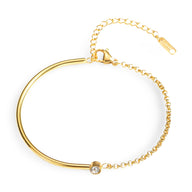 Bracelet fin en titane doré avec chaîne fine et pierre de zirconium brillante.