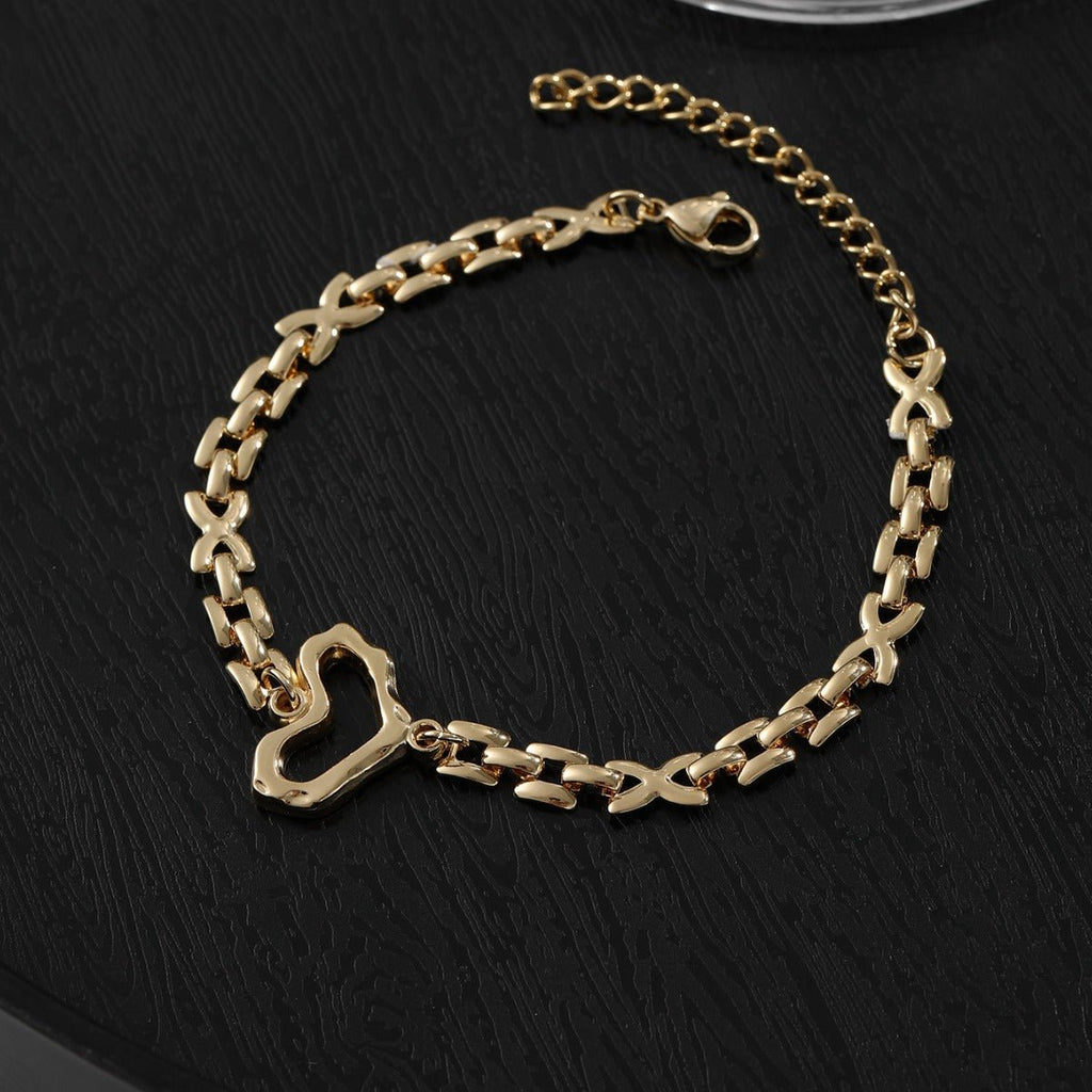Bracelet doré en acier inoxydable avec maille moderne difforme et pendentif cœur ajouré.