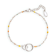 Bracelet fin en argent sterling avec deux anneaux entrelacés et perles colorées jaunes et turquoises.
