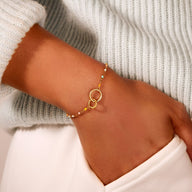 Bracelet double anneaux doré avec chaîne fine à billes, style élégant pour femme.