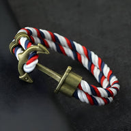 Bracelet double cordon rouge, blanc et bleu avec un motif ancre antique en métal bronze.