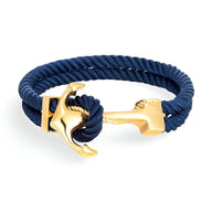 Bracelet double cordon bleu marine avec motif ancre dorée en acier, style marin élégant.